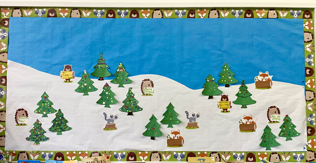 Winter Scene of trees on a hillside bulletin board with forest animals trim.