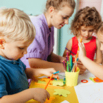 A teacher supports a small group of young children during a hands-on classroom activity, encouraging problem-solving, collaboration, and resilience through guided learning.